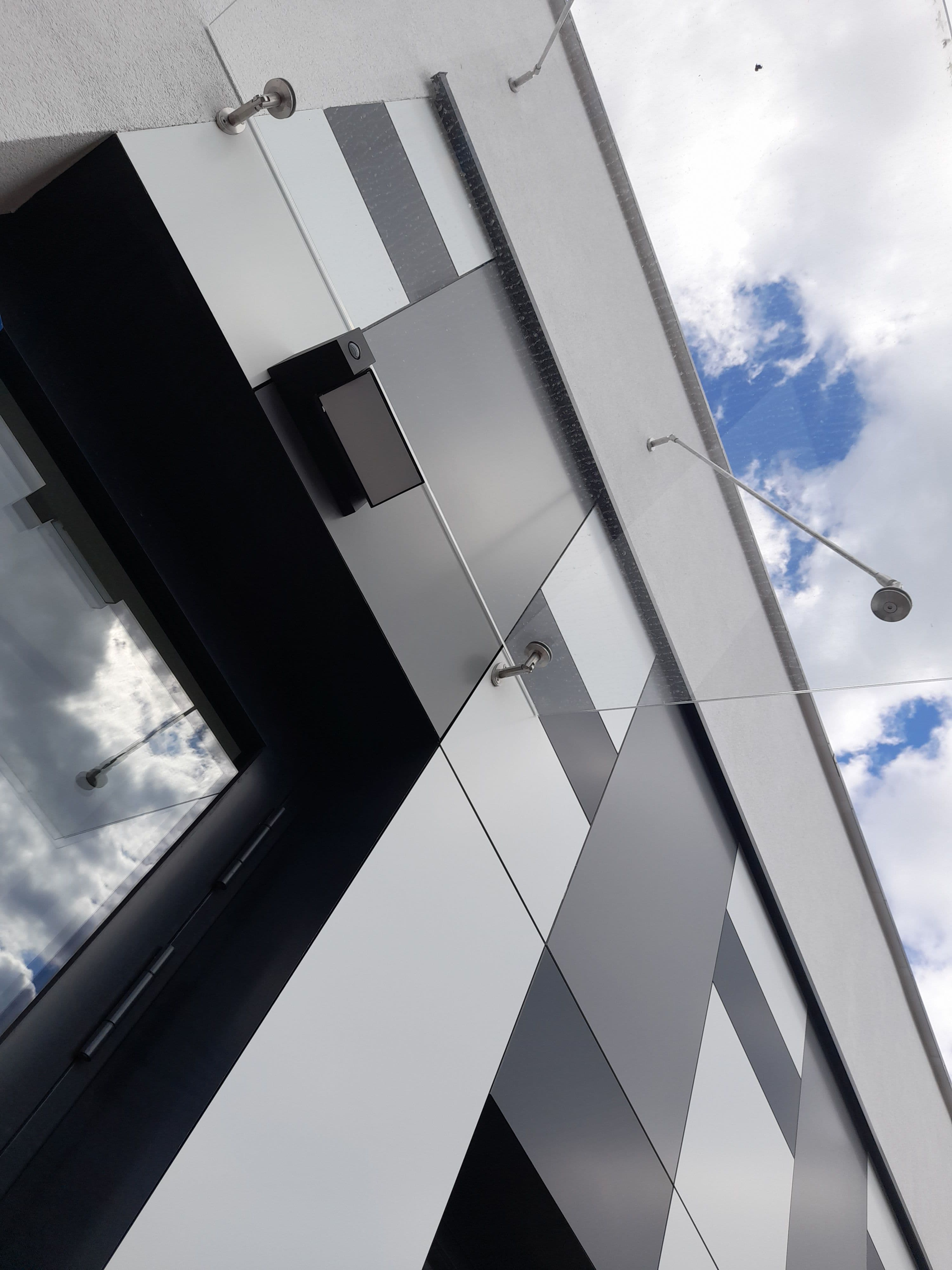 Fasada szklana oraz elewacja wielokolorowa na konstrukcji aluminiowej w budynku na planie koła, szklane zadaszenie drzwi wejściowych