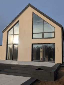 Aluminiowe: fasada dwukondygnacyjna, trójkątne okno panoramiczne oraz okno przesuwne typu HS w domu jednorodzinnym thumbnail