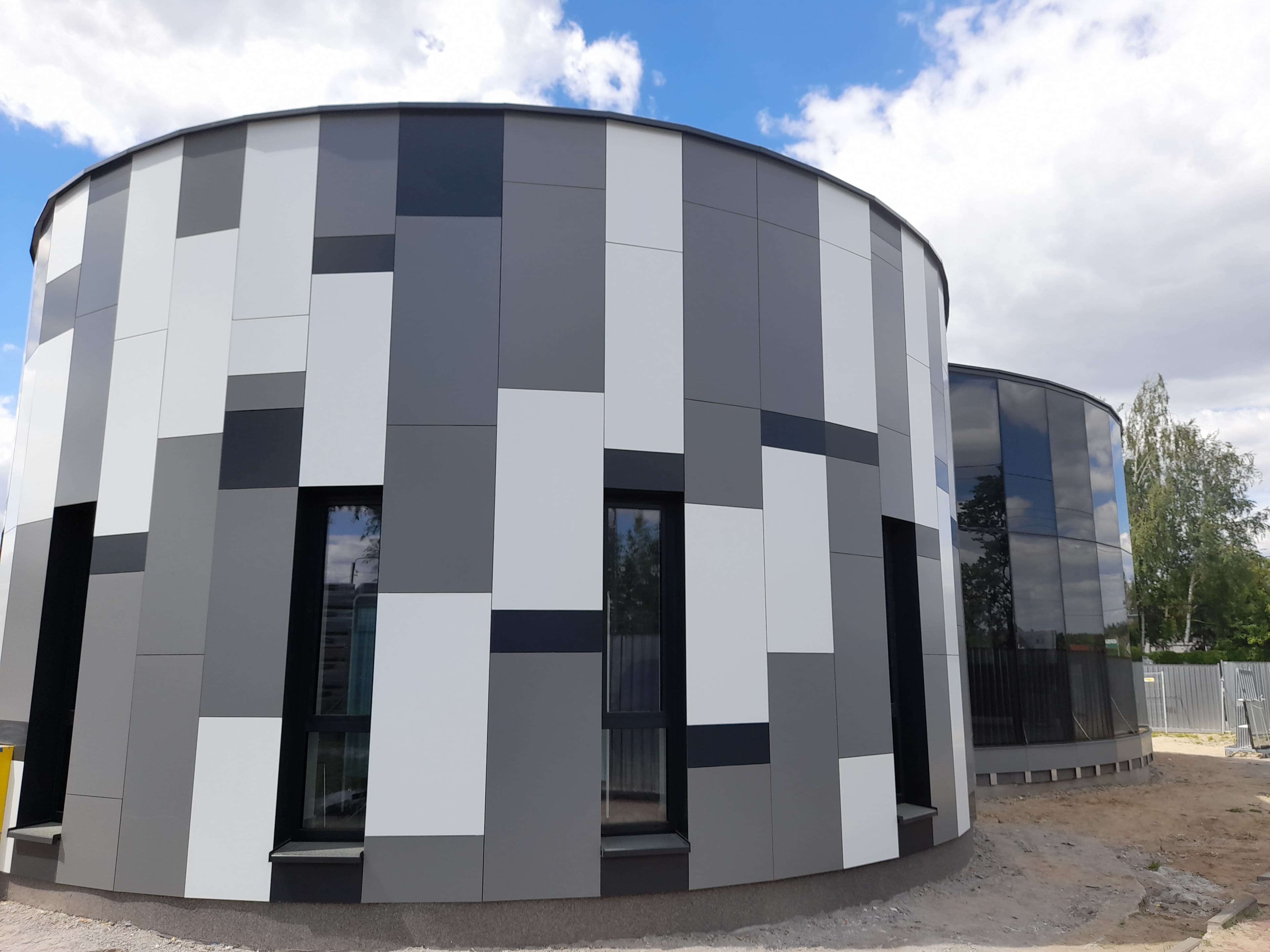 Fasada szklana oraz elewacja wielokolorowa z oknami na konstrukcji aluminiowej w budynku na planie koła